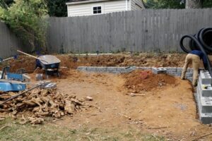Top Gardens installing a French drain and retaining wall in a Charlotte backyard.