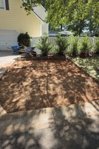 Dark stone gravel bed installation by a top garden landscaping service in Charlotte, NC in progress